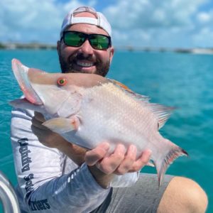 Captain Zander proudly holding a freshly caught hogfish on Lightly Salted Charters' boat.