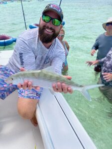 Captain Zander proudly displaying a freshly caught bonefish during an exciting Lightly Salted Charters adventure