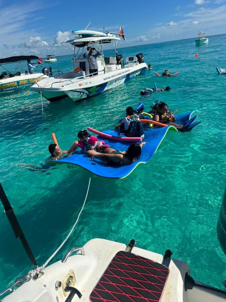 Guests enjoying a lily pad float between two charter boats under the sun in Islamorada waters.